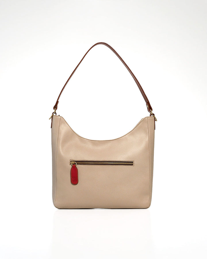 A beige leather shoulder bag with a brown leather strap and a small red leather tag, shown against a plain white background.